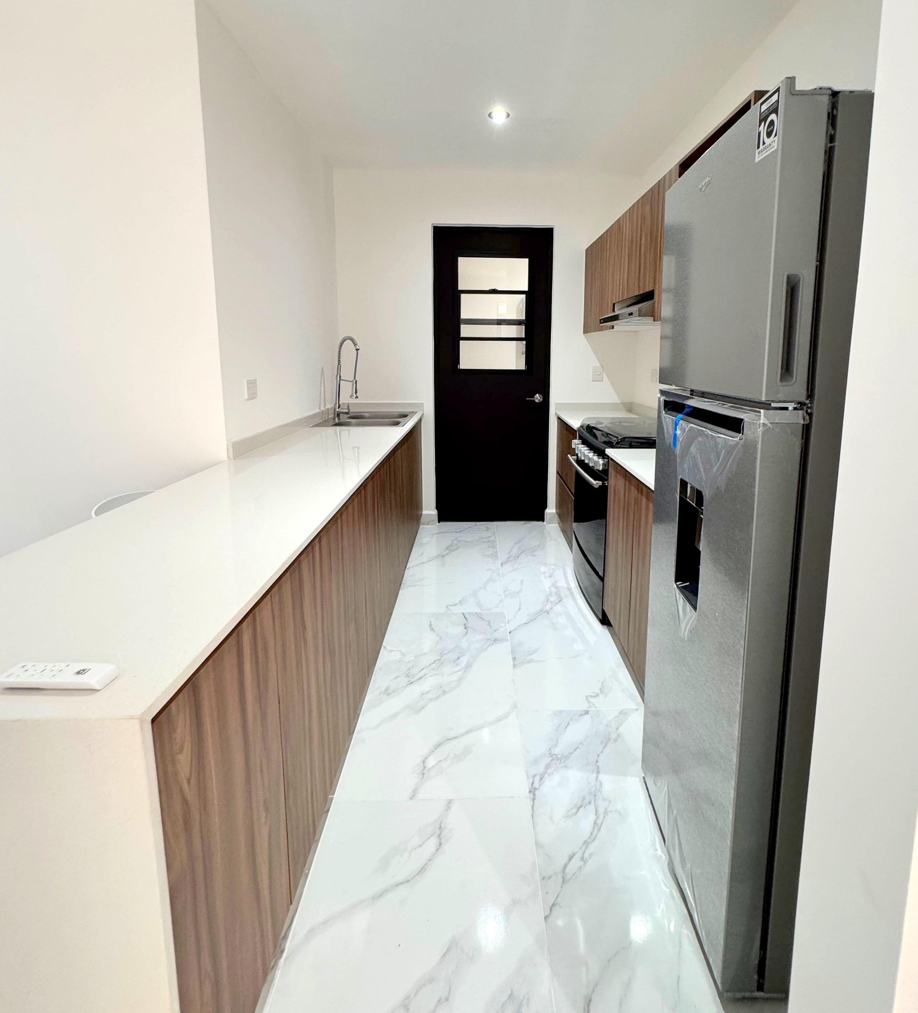 Spacious modern kitchen with sleek countertops and stainless steel appliances in a furnished apartment for rent in Playa del Carmen – La Selva Residences