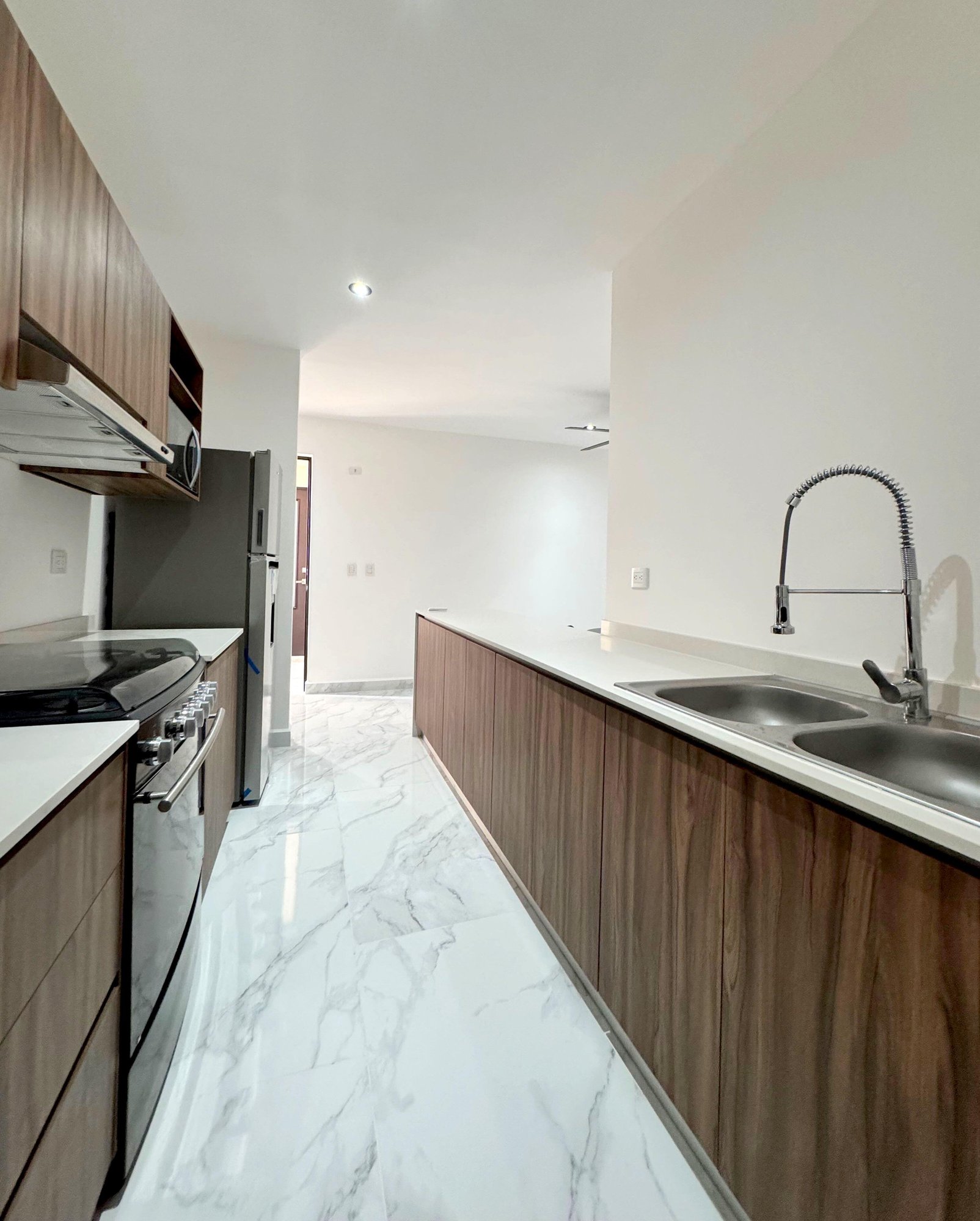Modern open kitchen with sleek finishes and integrated appliances in a furnished apartment for rent in Playa del Carmen – La Selva Residences