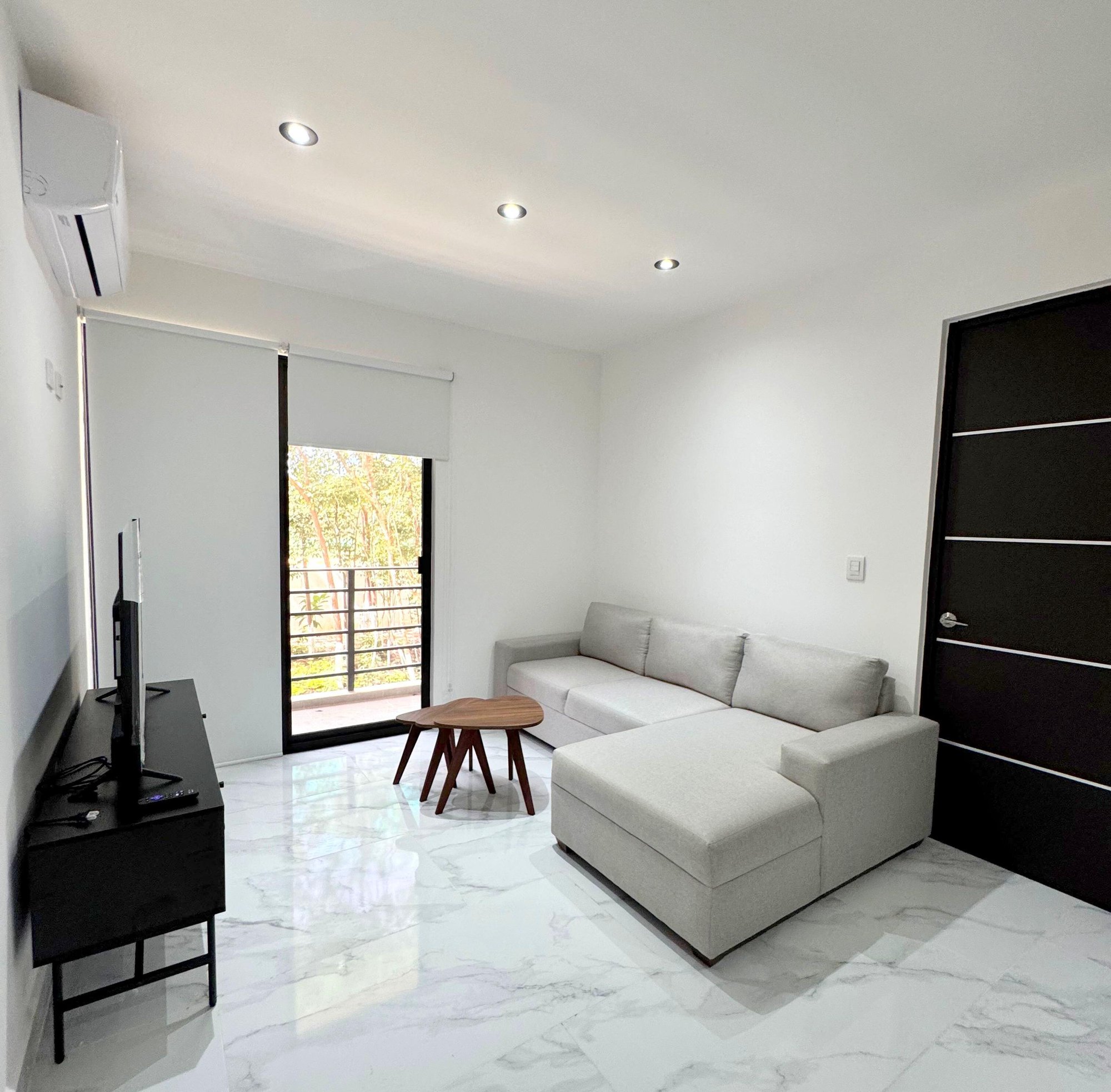 Bright and modern living room with balcony in a furnished apartment for rent in Playa del Carmen – La Selva Residences