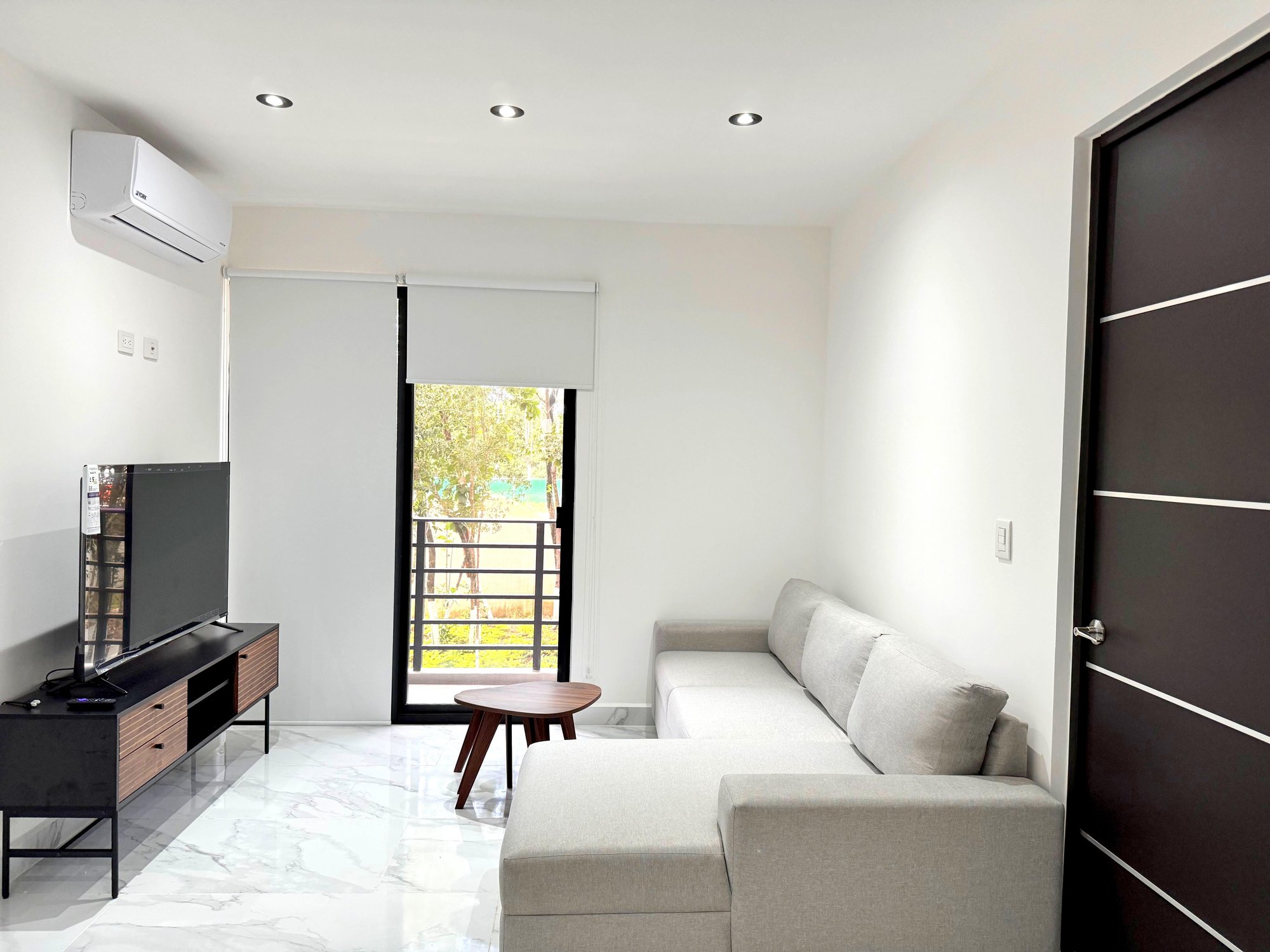 Elegant living room with balcony and natural light in a furnished apartment for rent in Playa del Carmen – La Selva Residences