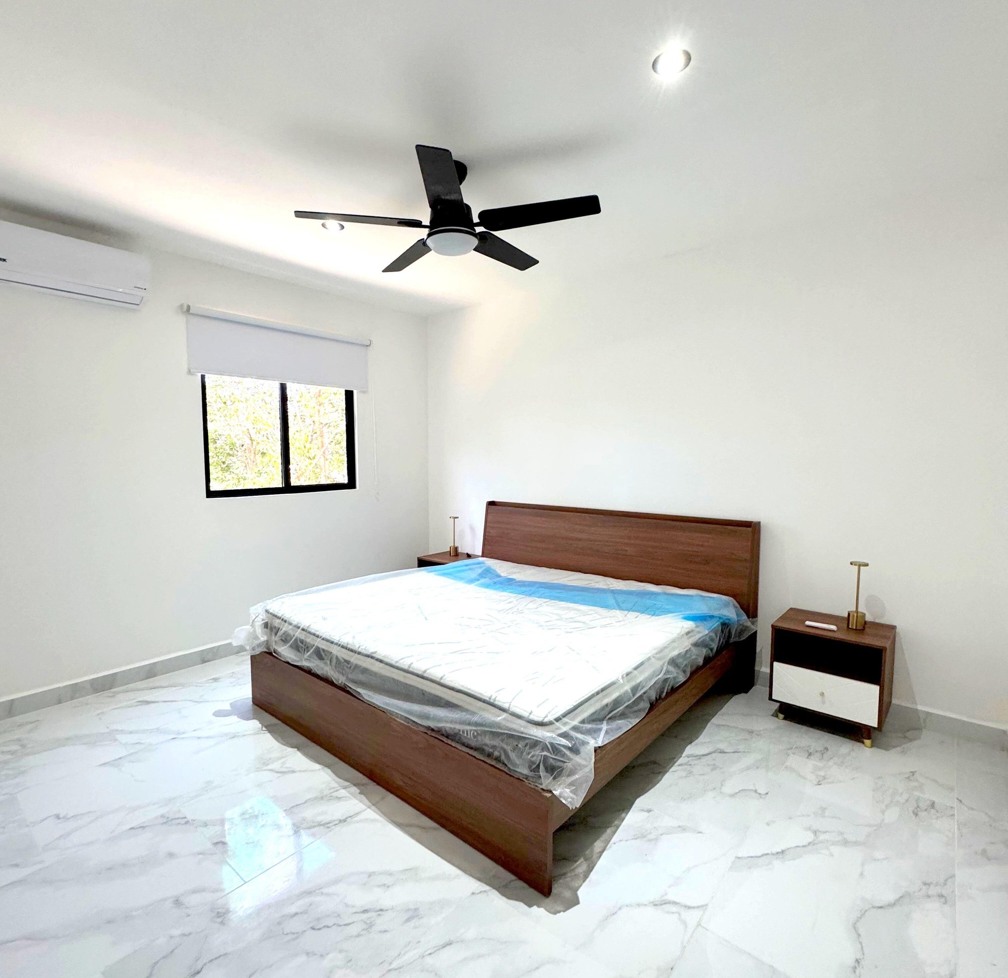 Bright master bedroom with large windows and modern furnishings in a furnished apartment for rent in Playa del Carmen – La Selva Residences