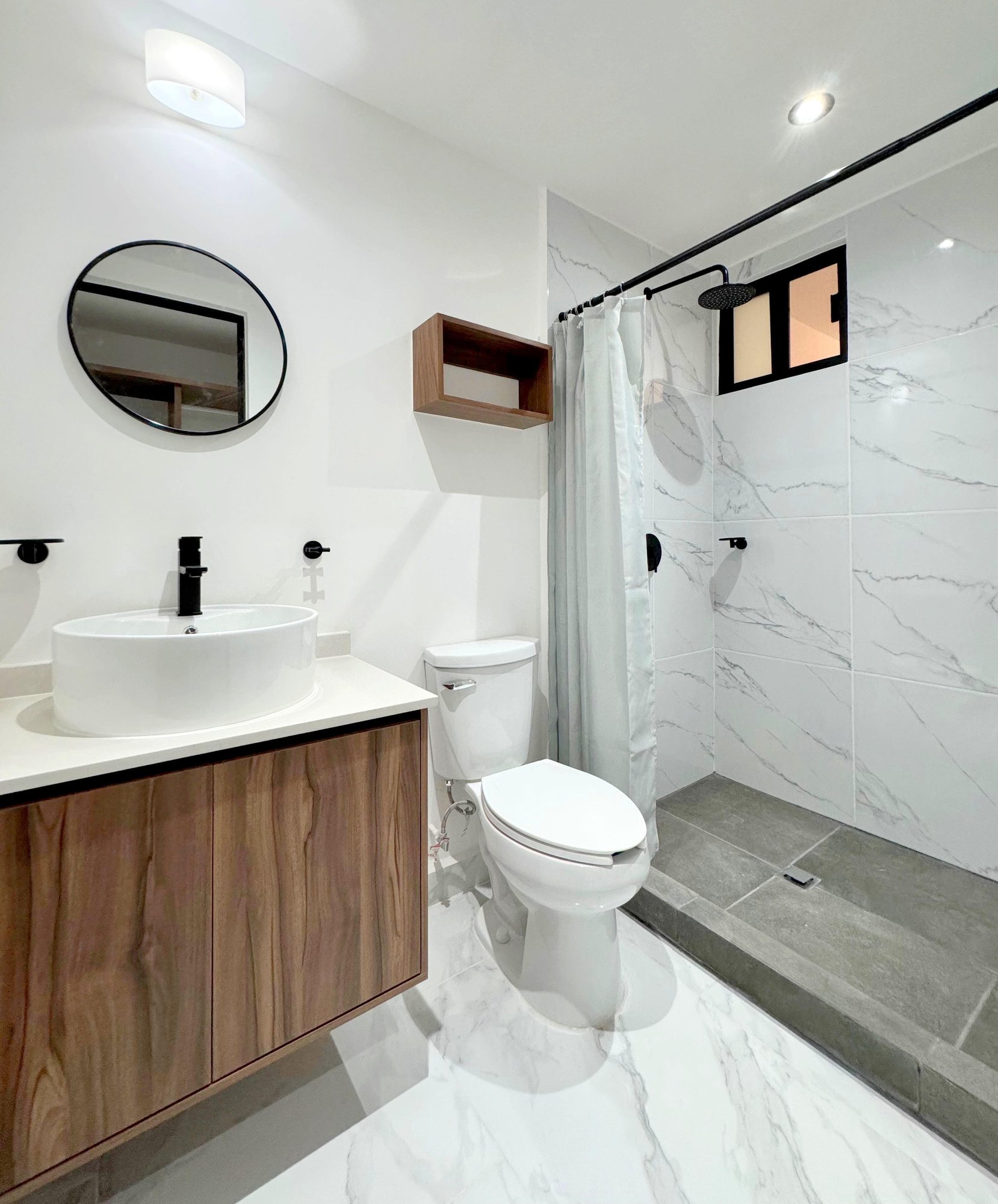 Modern bathroom with elegant finishes, and wooden vanity in a furnished apartment for rent in Playa del Carmen – La Selva Residences