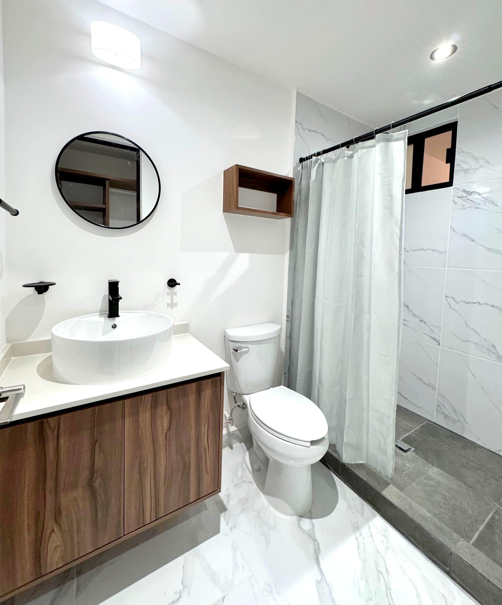 Modern bathroom with elegant finishes, and wooden vanity in a furnished apartment for rent in Playa del Carmen – La Selva Residences