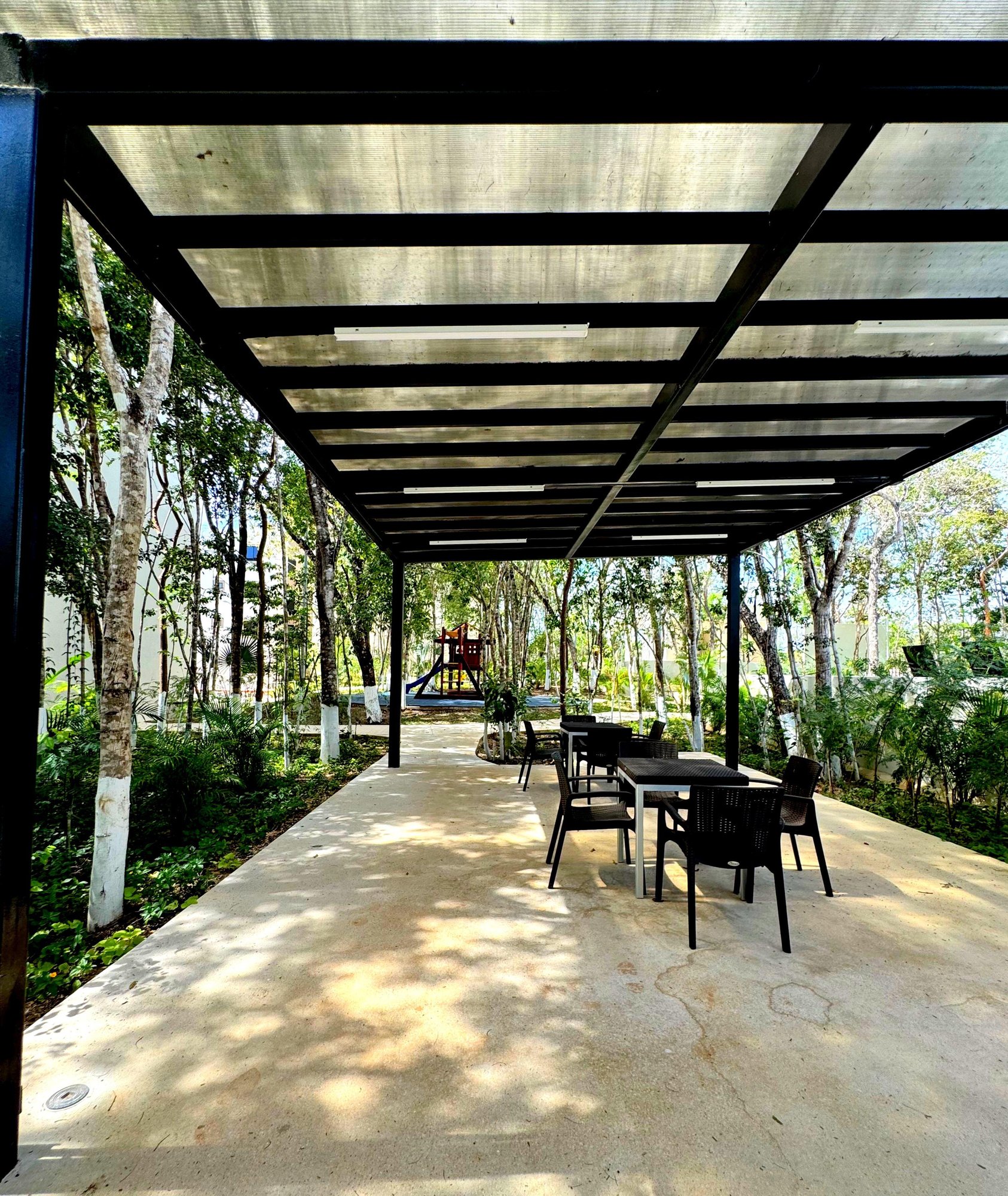 Outdoor covered seating area surrounded by nature at La Selva Residences – Ideal for relaxation and social gatherings in Playa del Carmen